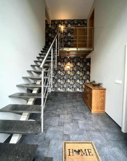 hall d entree et escalier avec peinture blanche et papier peint